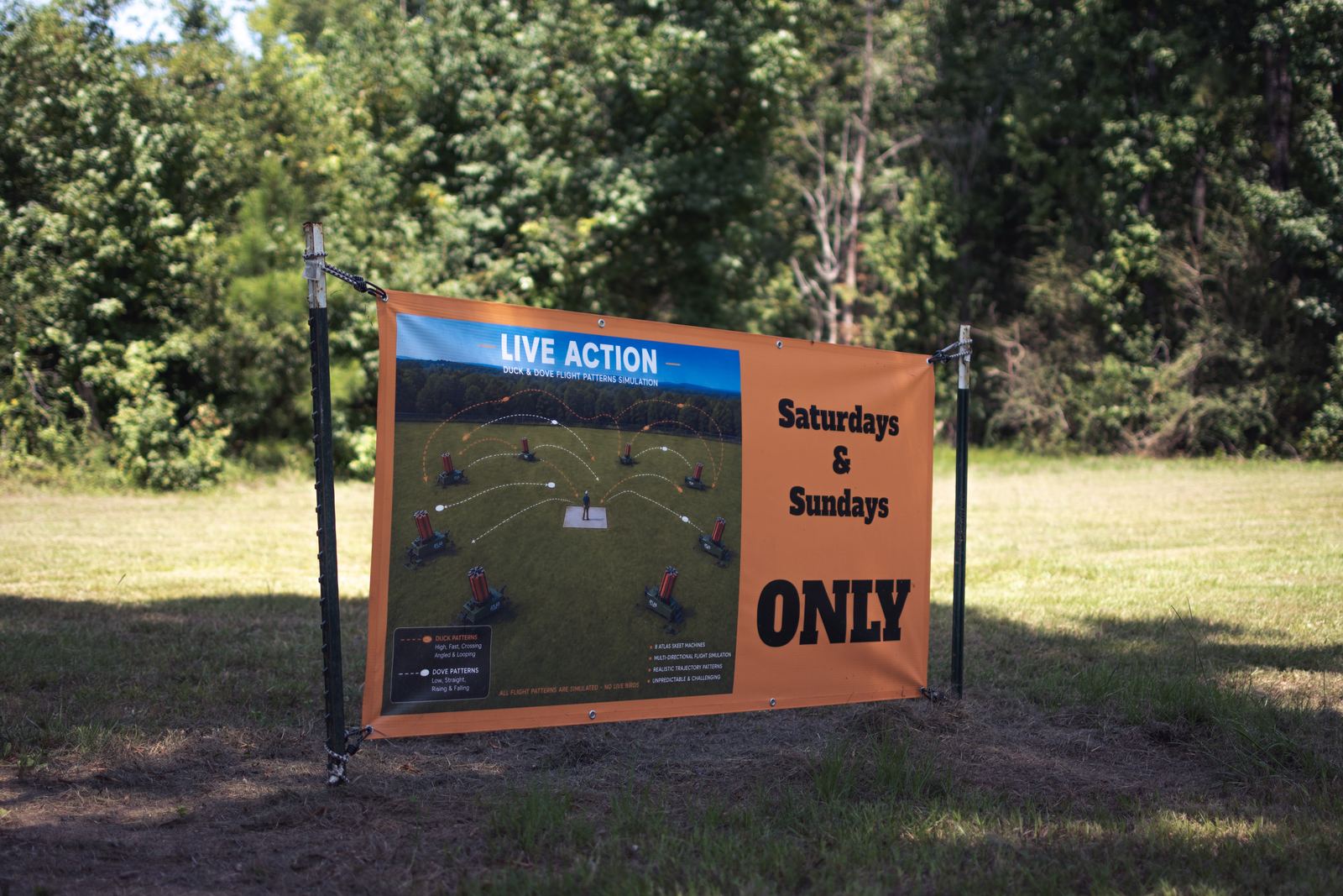 An orange banner at the edge of the field reading Live Action, duck and dove flight patterns simulation, Saturdays and Sundays only